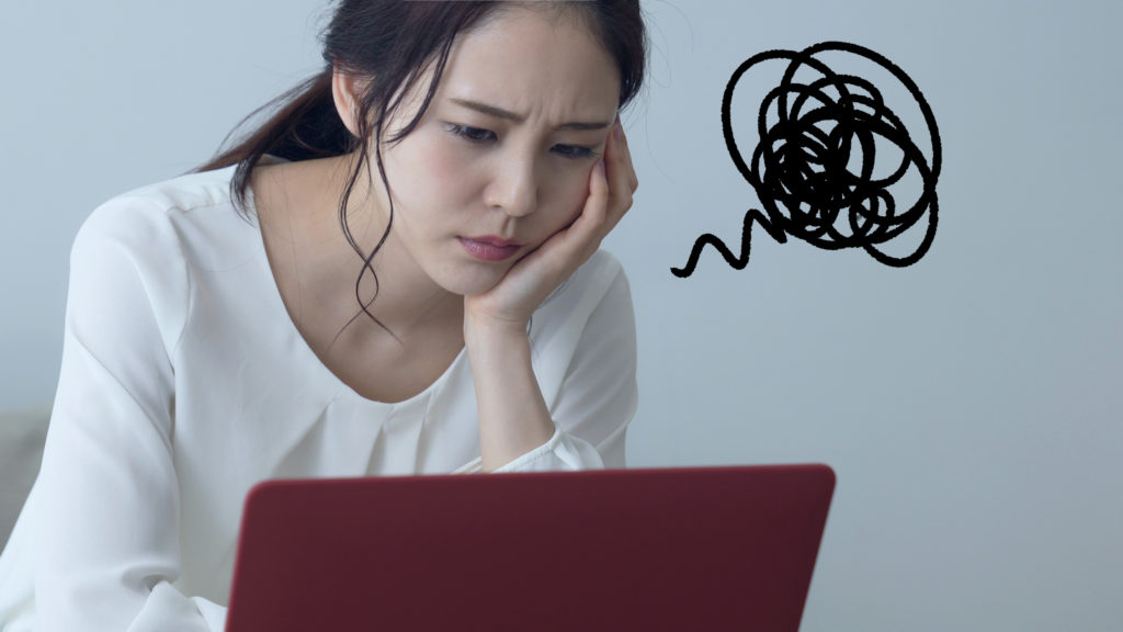 PCを前に悩む女性